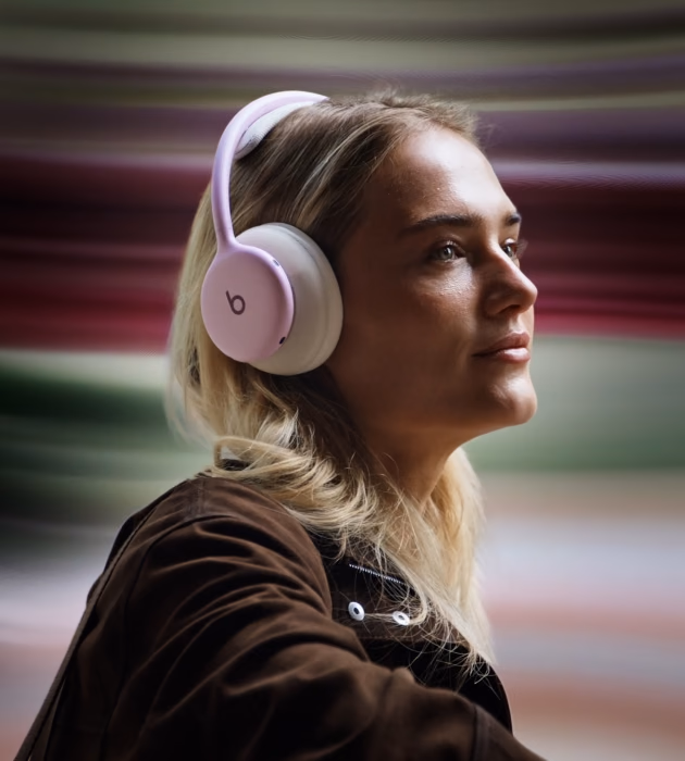 Woman wearing pink Beats 360 against a background of motion streaks