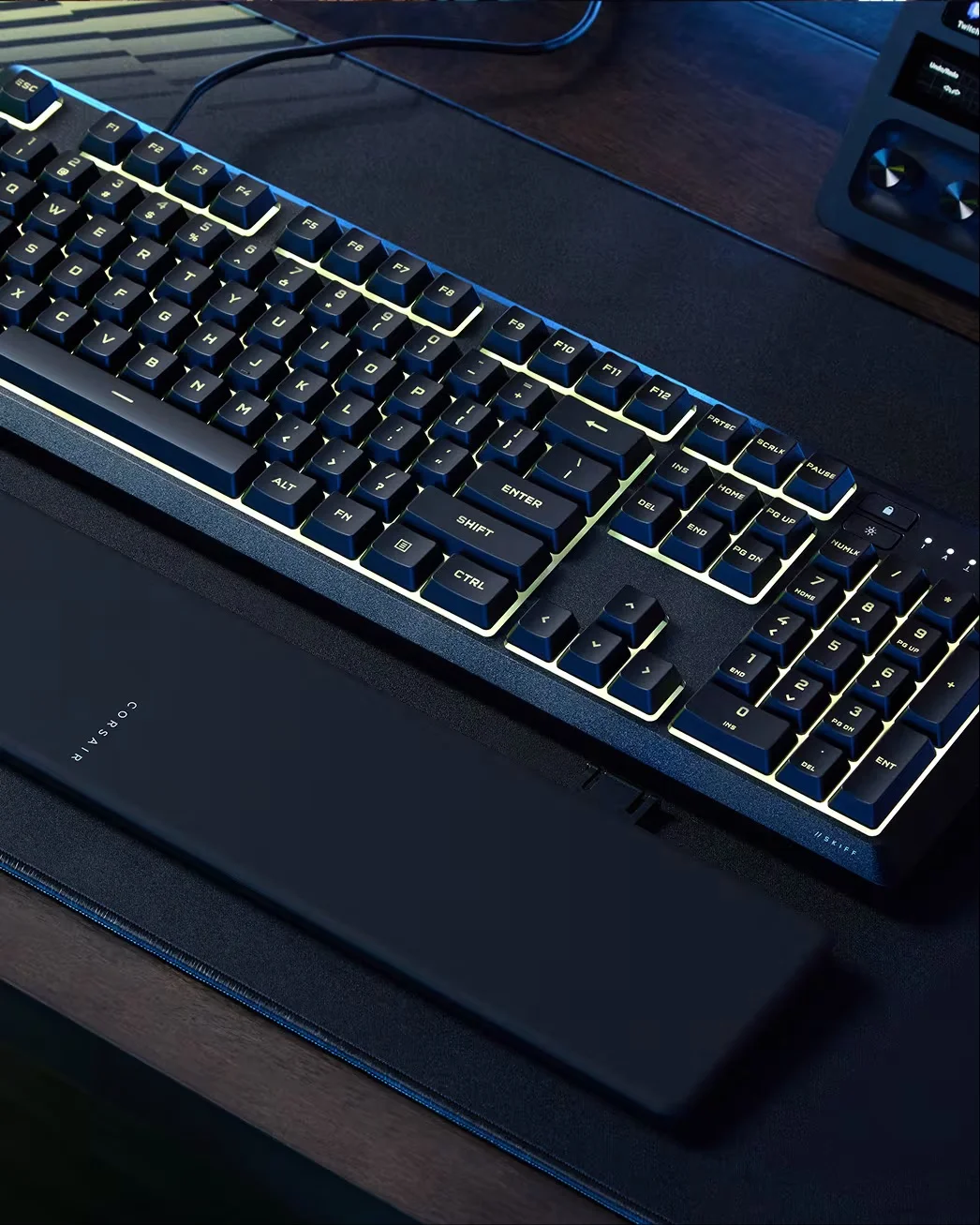 El Skiff 100 con el reposamuñecas extraíble acoplado sobre un escritorio oscuro