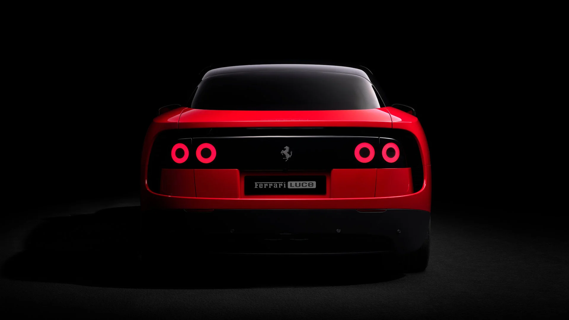 Rear view of the Ferrari Luce in red, showcasing the four red circular halos as taillights and the Ferrari Luce license plate centered