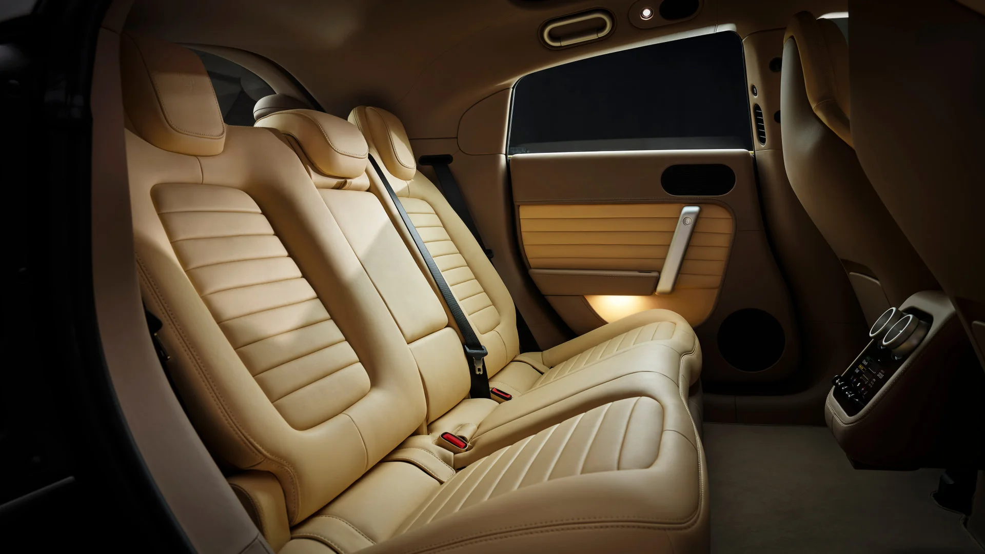 Rear seats of the Ferrari Luce in light beige leather, showing the two seats with seatbelts and control panel between seats