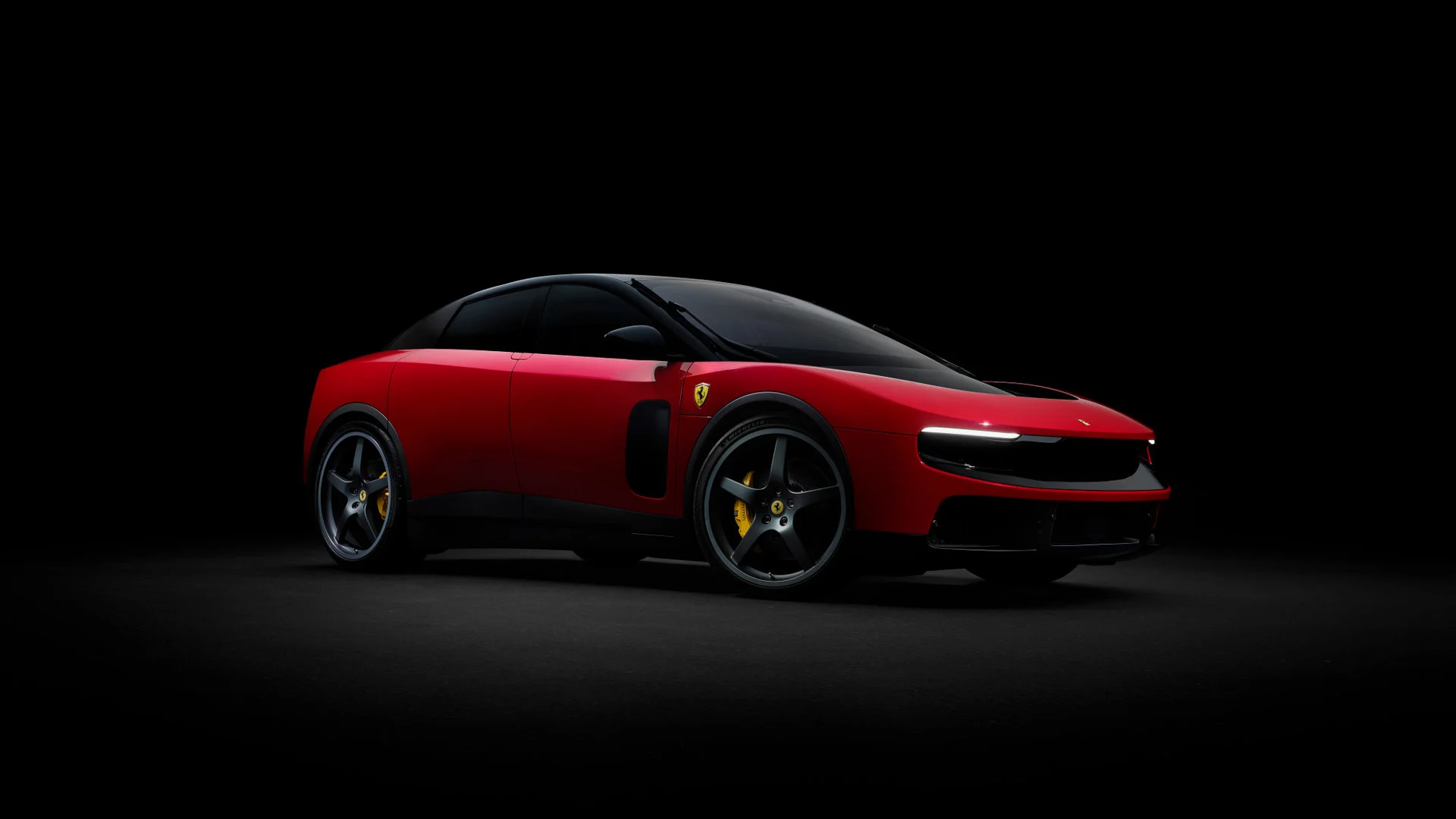 3/4 front view of the Ferrari Luce in Rosso Corsa red, photographed in studio with black background, showing the interaction between front and profile with dark wheels