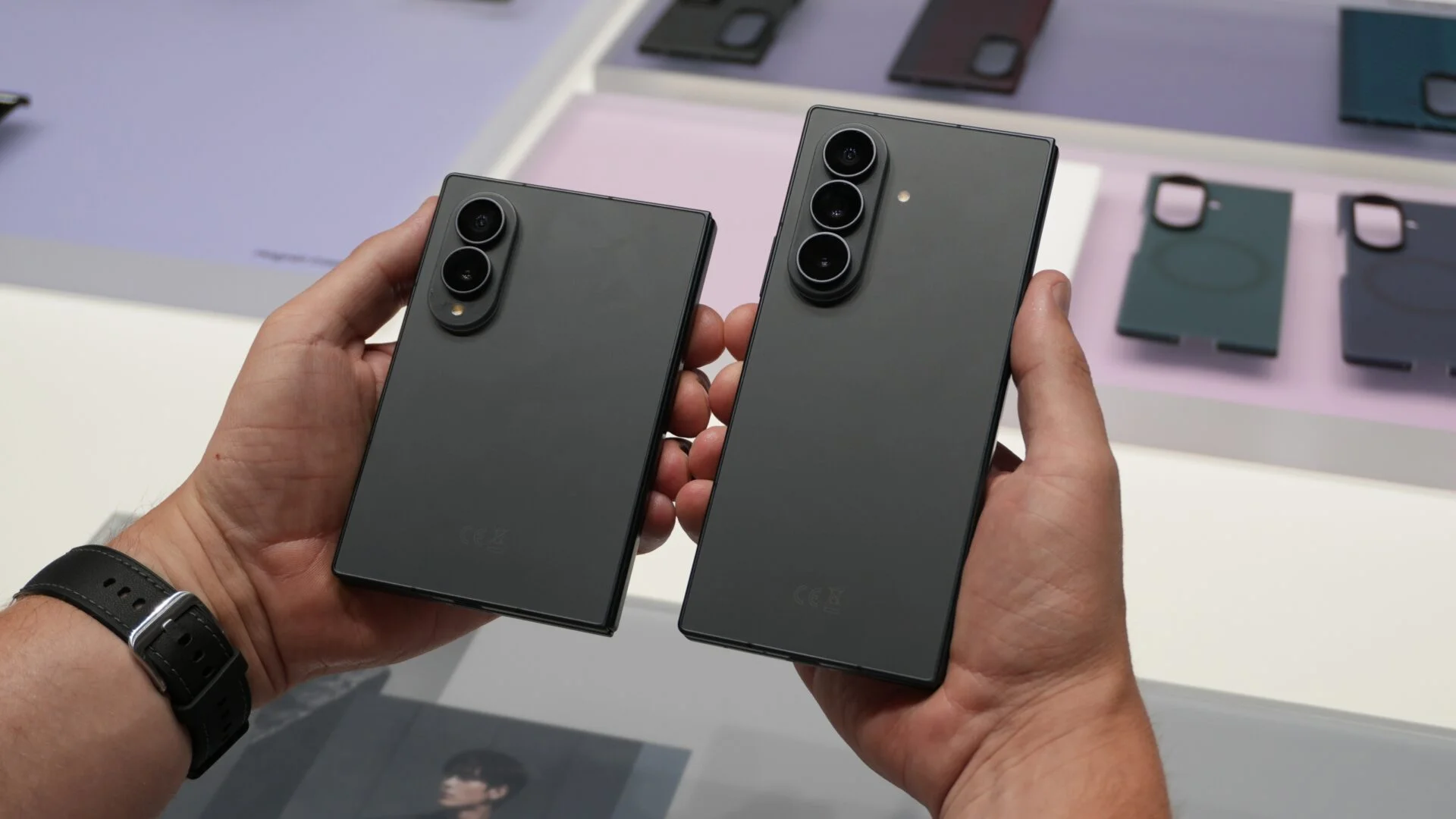 El Galaxy Z Fold 8 y el Fold 8 Ultra plegados y sostenidos uno al lado del otro, con sus módulos de cámara a la vista