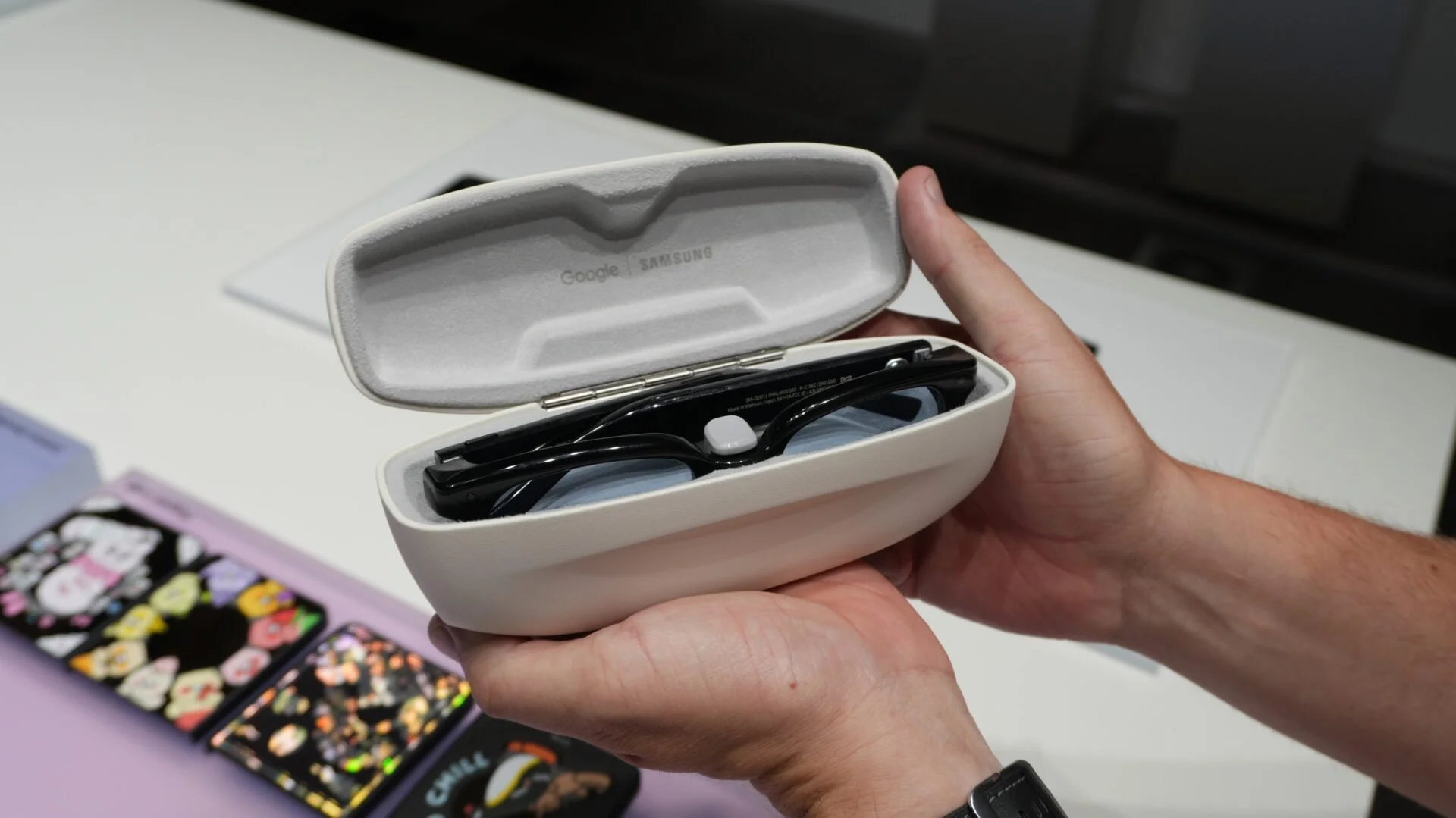 El estuche de carga abierto de las gafas inteligentes de Samsung con las gafas negras adentro