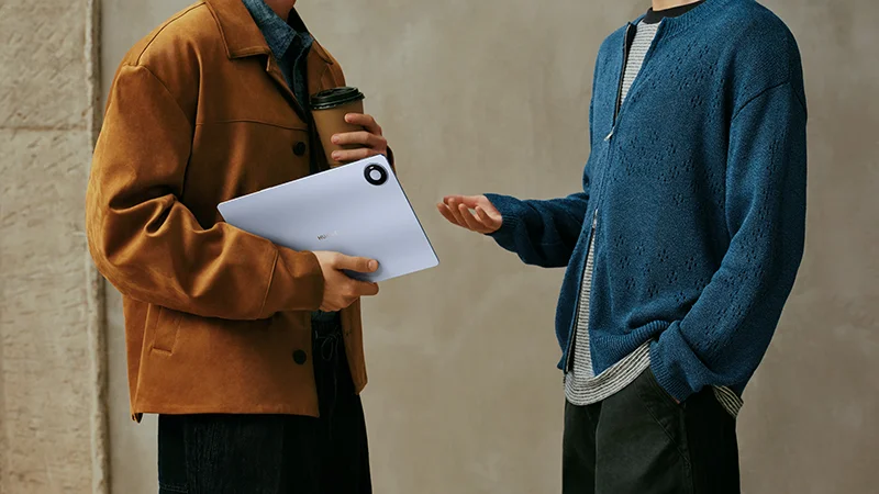 Dos personas conversando en la calle, una de ellas con la Huawei MatePad Pro Max bajo el brazo.