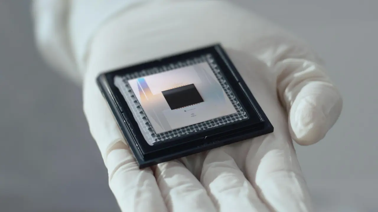 Una mano con guante sostiene el chip cuántico Willow de Google.