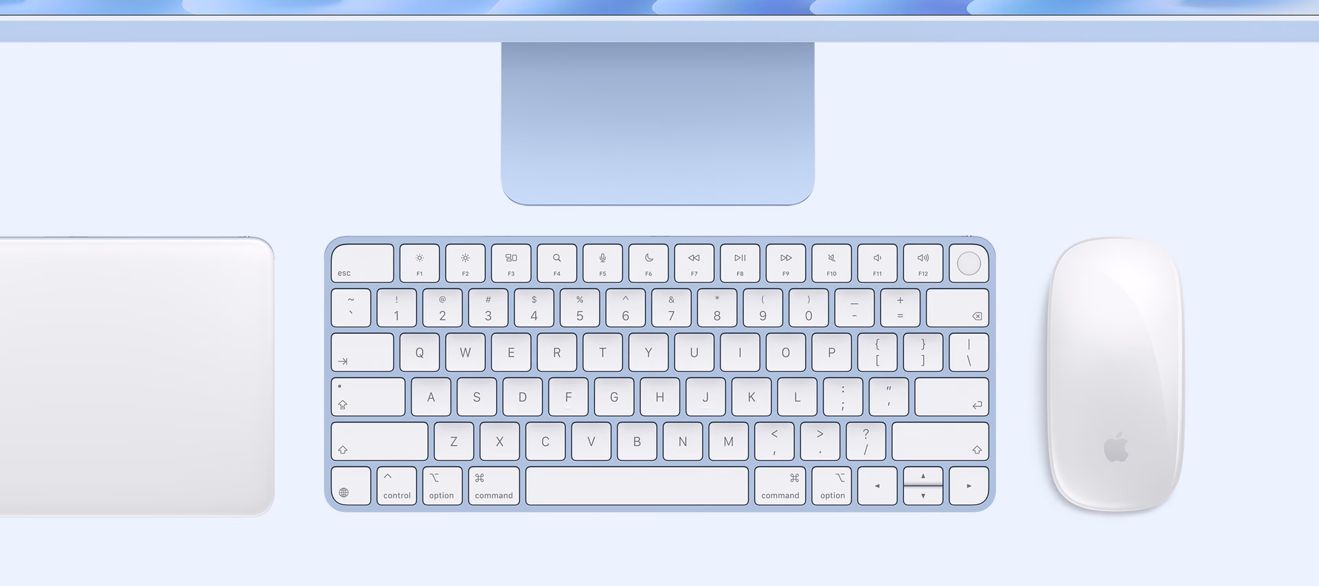 Keyboard, trackpad, and mouse next to a blue iMac