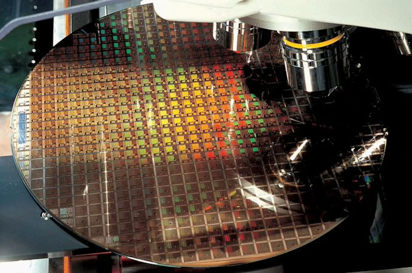 Oblea de silicio con cientos de chips bajo un equipo de inspección en una fábrica