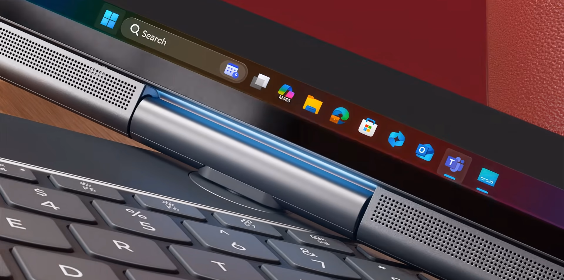 Detalle de la bisagra motorizada cilíndrica del ThinkBook Plus Gen 7 Auto Twist, flanqueada por los dos parlantes del panel