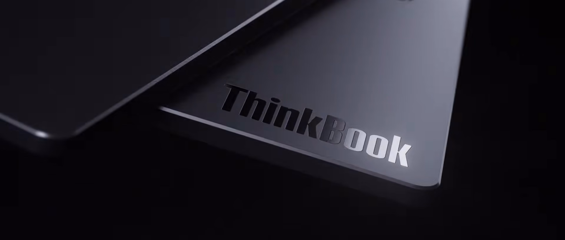Logo ThinkBook grabado en la tapa del portátil sobre fondo negro