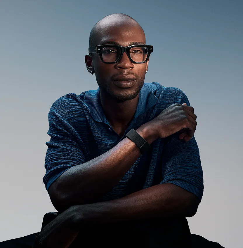 Man wearing Meta Ray-Ban Display and Meta Neural Band against a gray background