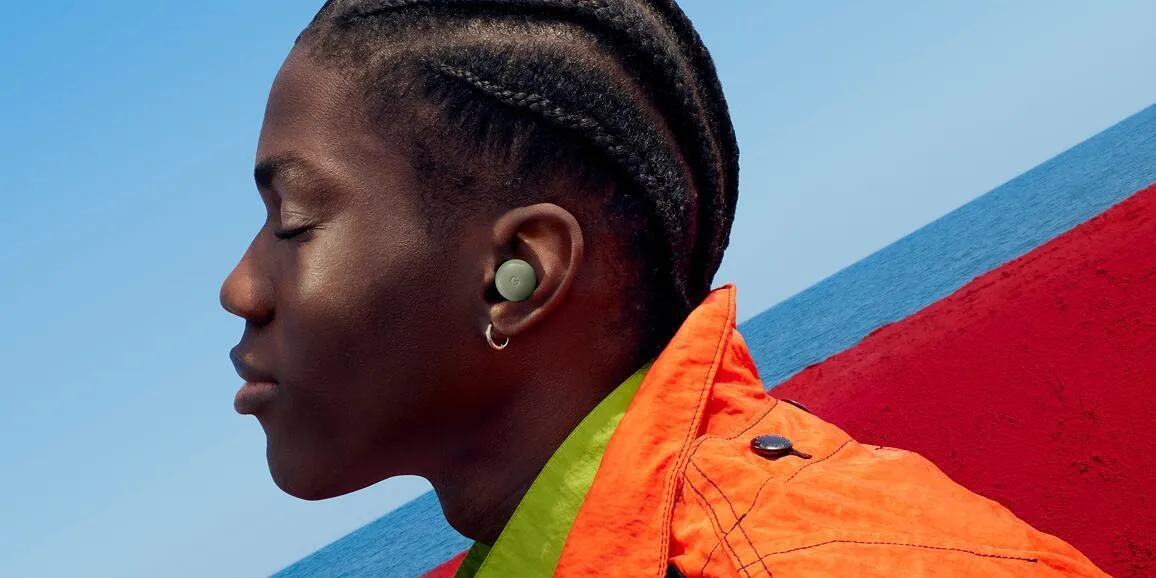 Una persona de perfil con un Pixel Buds Pro 2 en color Olive puesto en la oreja, con el mar de fondo