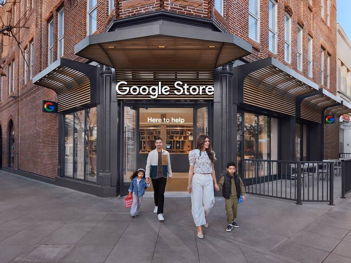 Una familia sale de una tienda física de Google Store con el cartel iluminado sobre la puerta