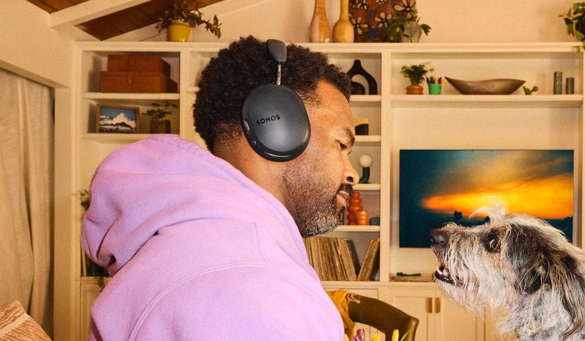 Persona escuchando música con el Sonos Ace Ultra en el living de una casa