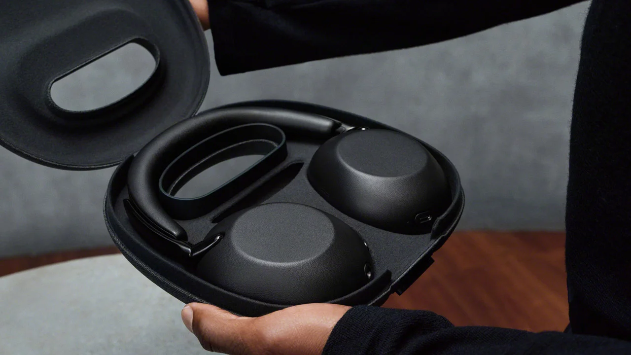 Person holding the bag-style case of the Sony 1000X The Collexion open in Black color, with the headphones stored inside