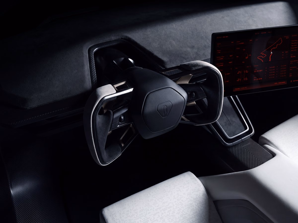 Detail of the Tesla Roadster yoke steering wheel next to the screen