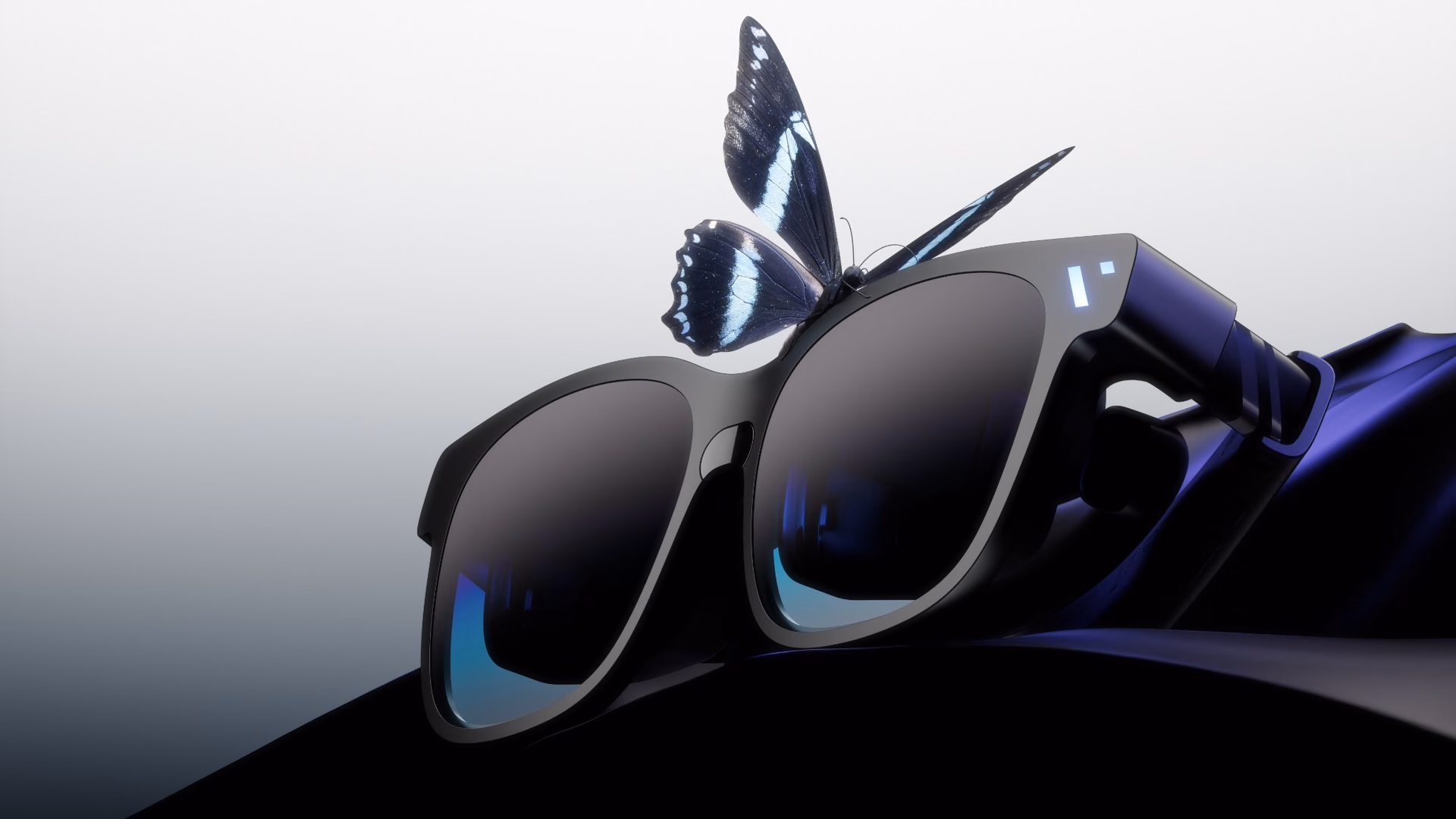 Una mariposa posada sobre el marco negro de las VITURE Pro 2 apoyadas sobre una tela oscura.