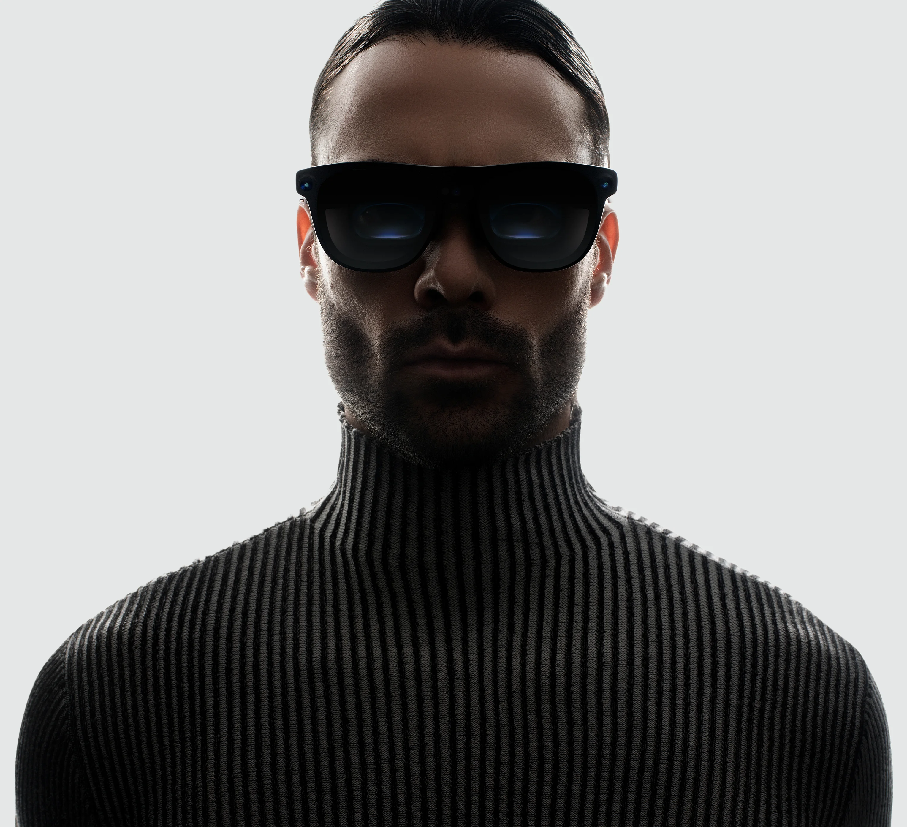 Un hombre con las gafas XREAL Aura puestas en un retrato de estudio sobre fondo gris