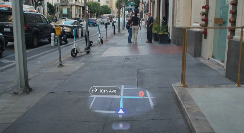 Ejemplo de navegación AR de Google Maps en Android XR proyectada sobre la vereda de una calle