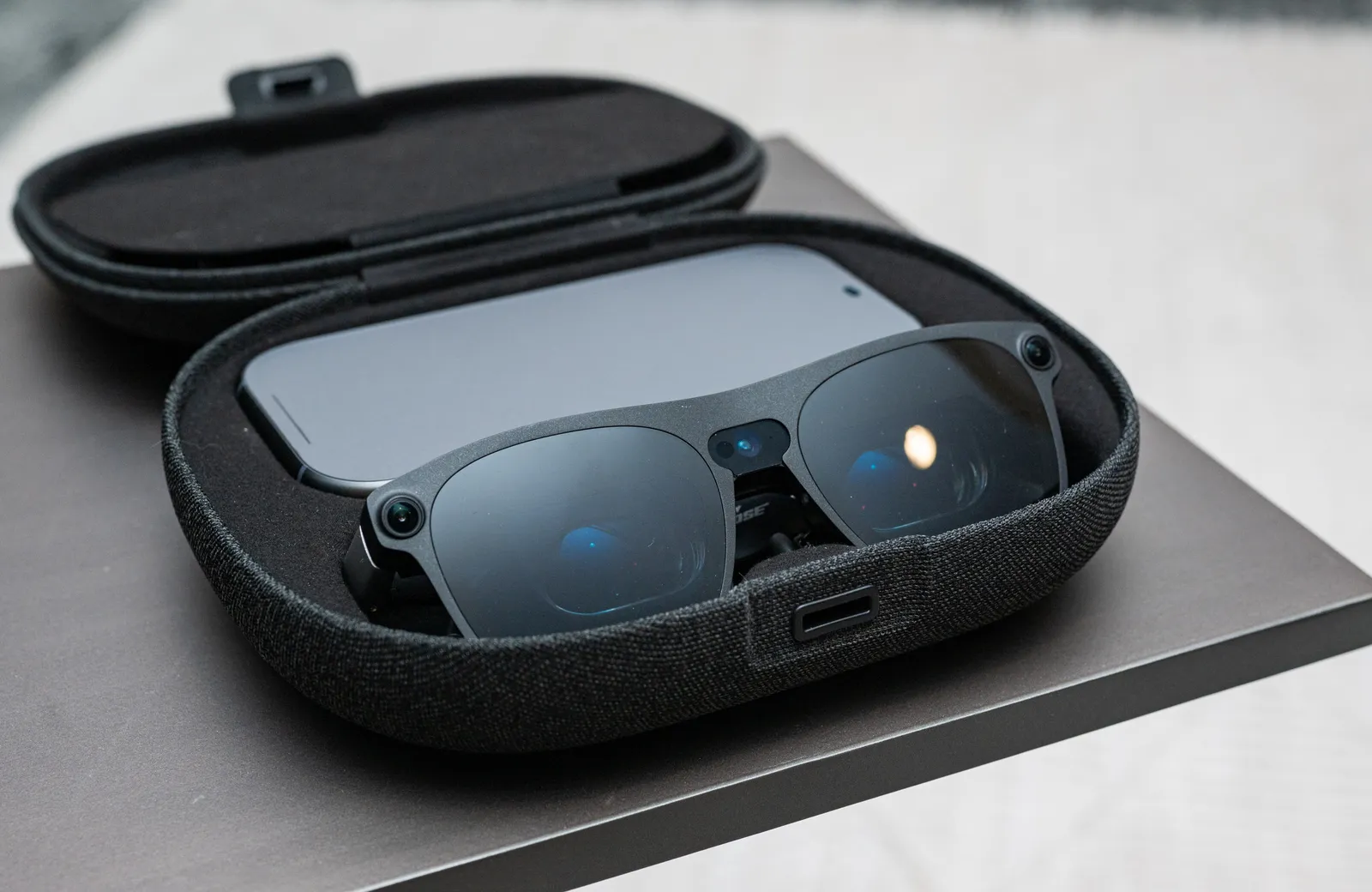 Las gafas XREAL Aura y su puck guardados en el estuche de transporte abierto